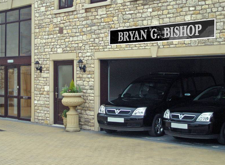Bryan G. Bishop funeral home with two black hearses in a garage